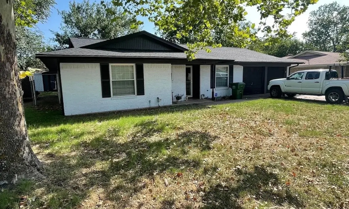 Professional roofing crew working on a residential roof in Iona